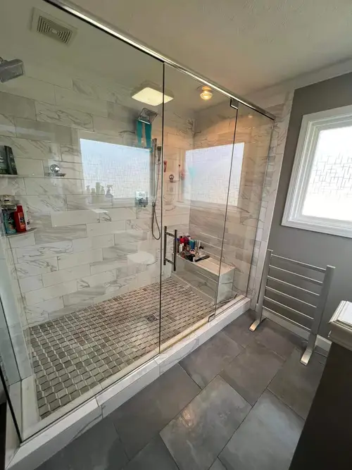 Clean white bathroom and laundry room combo with shower, sink, and washer in Durham NC home